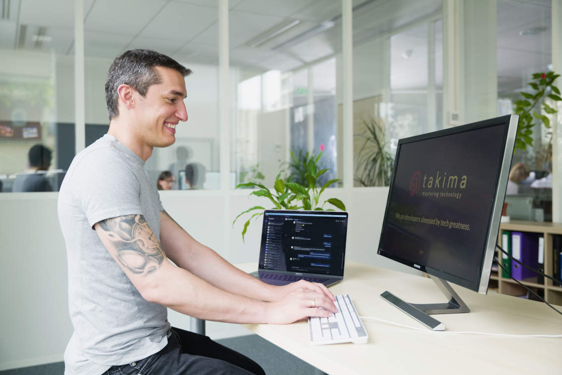 A happy trainee working on Takima training, typing on his keyboard.